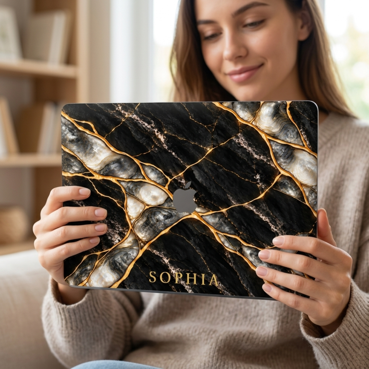 Woman holding a MacBook in a Black Pearl black marble printed case personalized with the name SOPHIA.