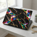 MacBook in a Jewel Tone black marble hard shell case with gold veins and colorful opal inlay, personalized with SOPHIA, on a white desk. Printed effect, smooth matte finish.