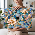 Woman holding a MacBook in the hummingbird and magnolia stained glass effect case, Apple logo visible through the unprinted logo area, in a bright living room.