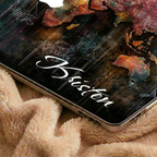Close-up detail of a personalized artistic world map MacBook case by TrioAuraDesign showing the elegant white script name "Kristen" printed on the lower corner of the design. The hard-shell case features vibrant abstract world map artwork with rich watercolor textures, layered paint effects, and a smooth protective finish. This detailed view highlights the premium print quality, slim profile, rounded edges, and precise fit for MacBook Air and MacBook Pro models.