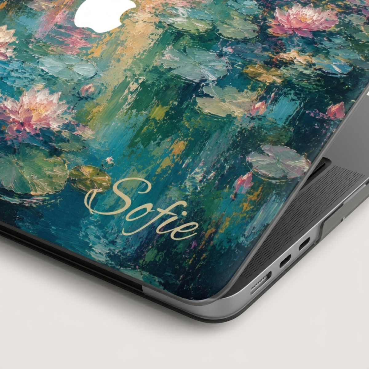 Close-up of the corner of a water lilies MacBook case showing the personalized name Sofie and the printed lily pad artwork.