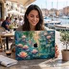 Smiling woman at a seaside café by the harbor working on a MacBook in a water lilies printed case.