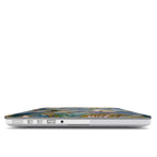 Side profile view of a closed MacBook showing its slim ports and the precise fit of the protective hardshell case. The top cover displays the edge of the intricate stained glass mosaic design with a hummingbird wing and gold outlines against the silver laptop body.