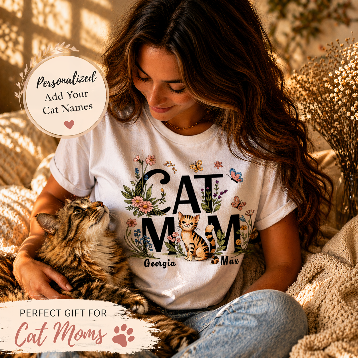 Lifestyle photo of a woman with her cat, wearing a personalized 'Cat Mom' floral T-shirt with custom cat names Georgia and Max, including 'Perfect Gift for Cat Moms' text overlay.