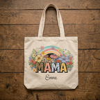 Custom MAMA tote bag mockup with a vibrant boho wildflower and leopard print graphic, flatlay on a weathered wood background