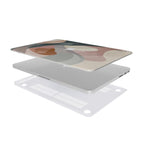 An exploded 3D view of a personalized MacBook case floating separately on a white background, featuring a modern abstract art top case with muted pink, cream, and grey tones and the monogram O.H., and a clear bottom shell with precision ventilation cutouts.