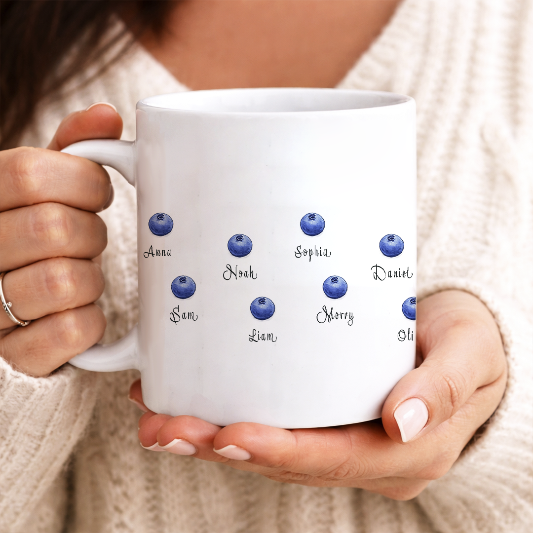 A custom personalized "Mom Fuel" mug sitting on a kitchen counter next to fresh blueberries, creating a cozy morning aesthetic.