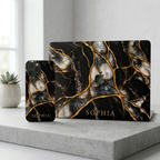 Matching set: Black Pearl marble iPhone case and MacBook case personalized with SOPHIA on a concrete surface.