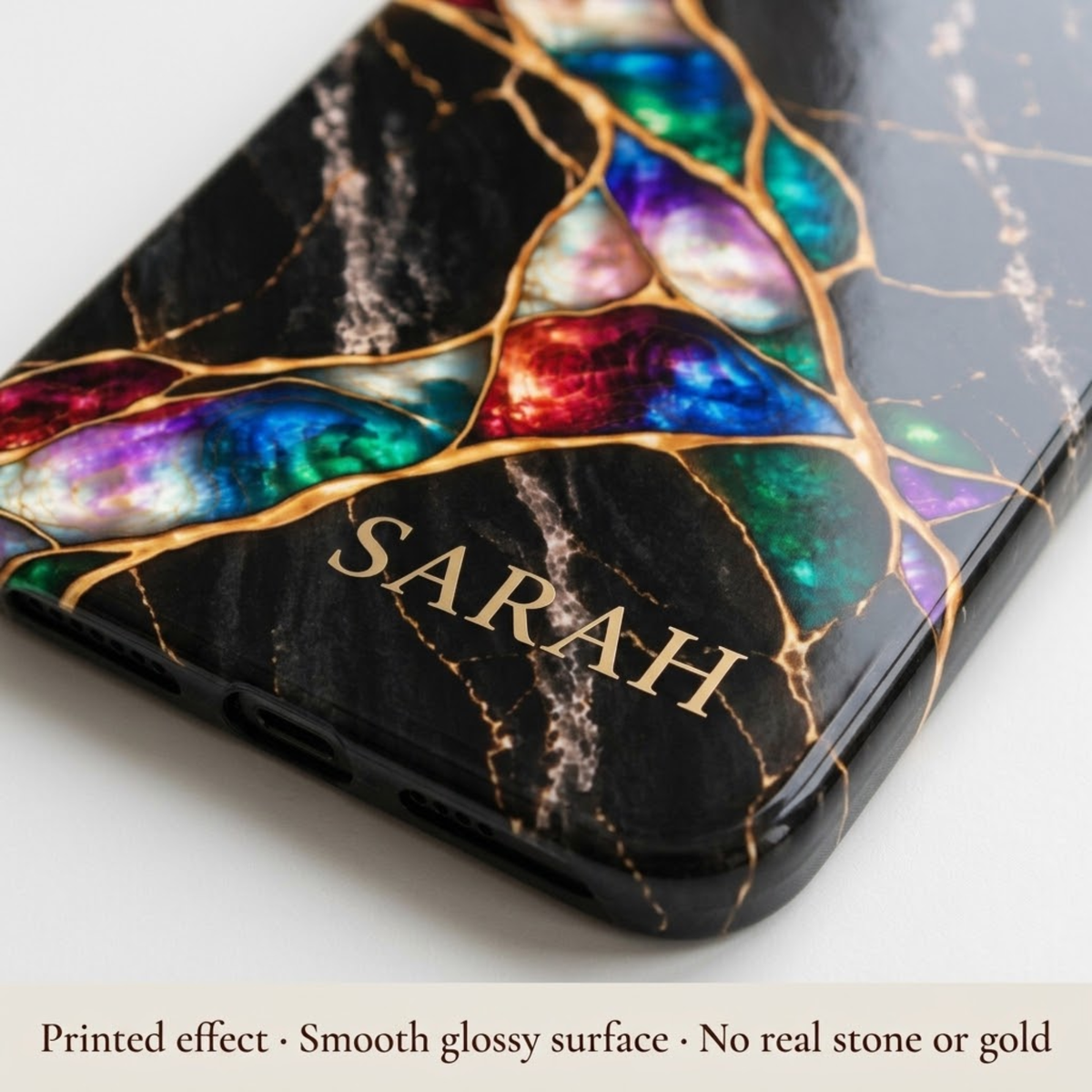 Close-up of a Jewel Tone marble iPhone case personalized with SARAH. Printed effect on a smooth glossy surface, no real stone or gold.