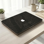 Personalized City Map MacBook case from TrioAuraDesign, shown closed on a light desk with a dark New York street map design. The smooth hard shell features custom city text “NEW YORK,” coordinates, the phrase “YOUR PLACE. YOUR STORY,” and the Apple logo visible at center. Minimal lifestyle view of a custom map laptop cover for compatible MacBook Air, Pro, and Neo models.