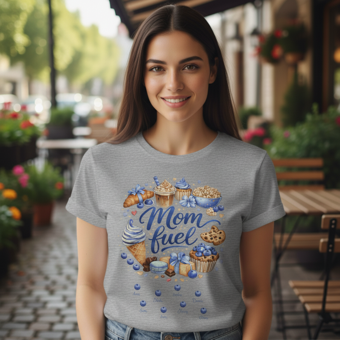 Happy older woman with long brown hair wearing a heather grey personalized "Mom Fuel" T-shirt, smiling while posing outdoors.