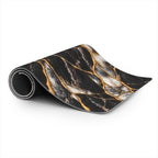 Rolled black marble desk mat in the Black Pearl style, showing the stitched edge, the black rubberized non-slip base and the soft printed top with gold vein and pearl-white marble details.