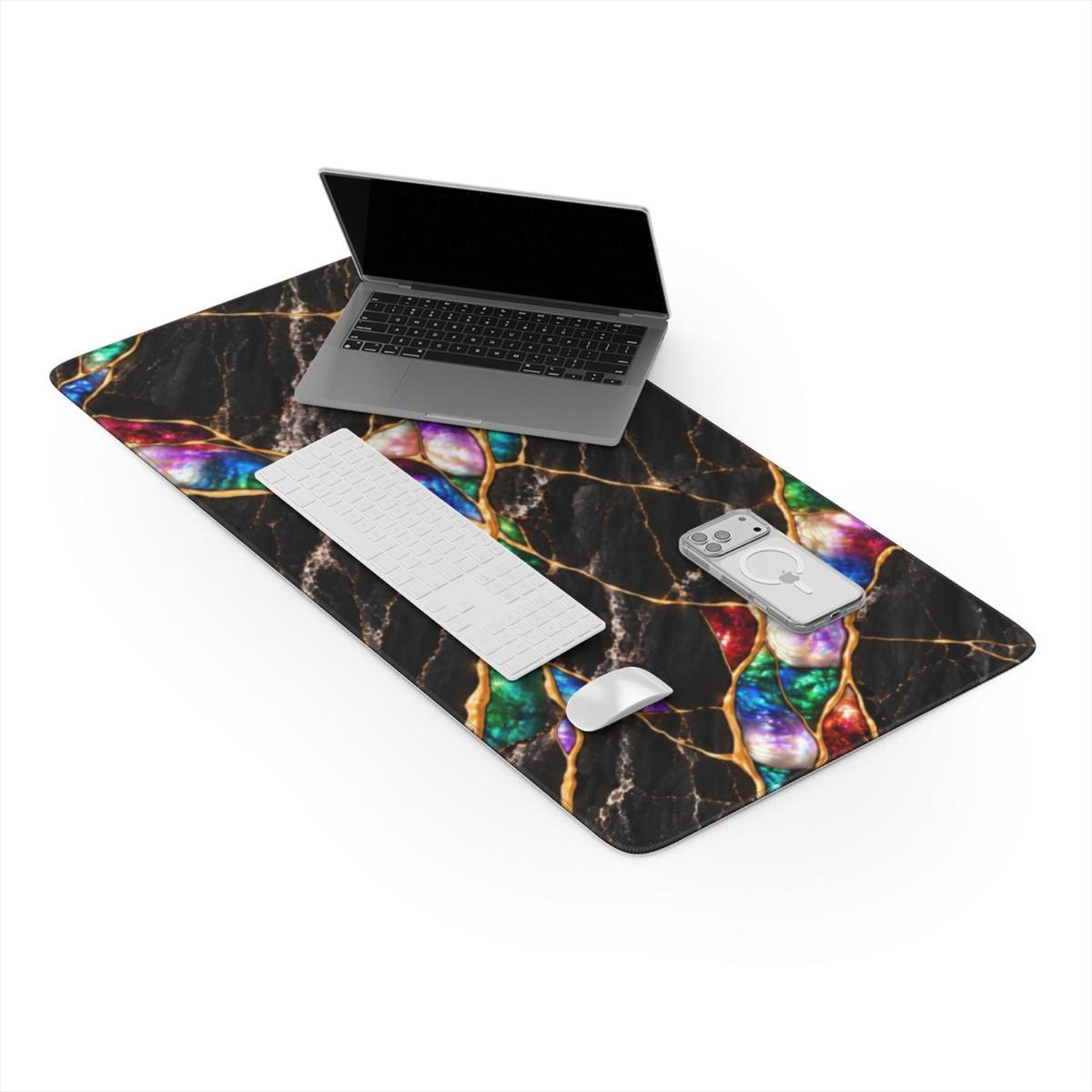 Jewel Tone black marble desk mat on a white background with a laptop, keyboard, mouse and phone, showing the full printed design with colorful opal-like stones between gold veins and stitched edges.