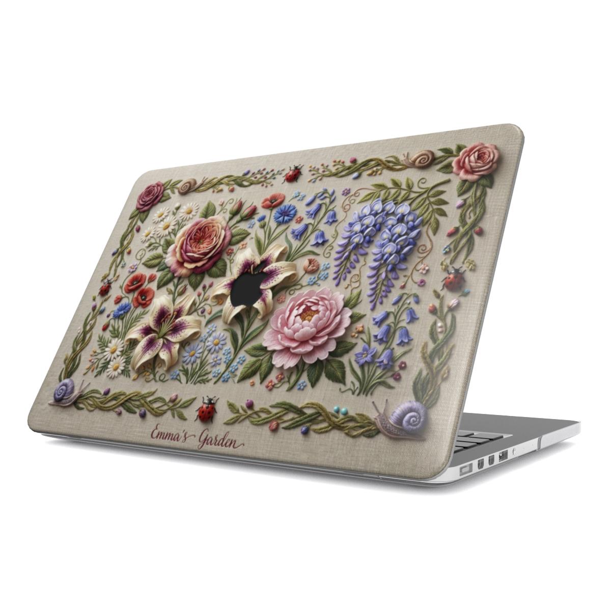 A semi-open silver laptop featuring a decorative hard shell case with a 3D-effect floral garden design. The cover shows a rich arrangement of embossed roses, lilies, and wisteria on a beige linen-textured background, accented with small ladybugs, snails, and the elegant script text "Emma's Garden" at the bottom.