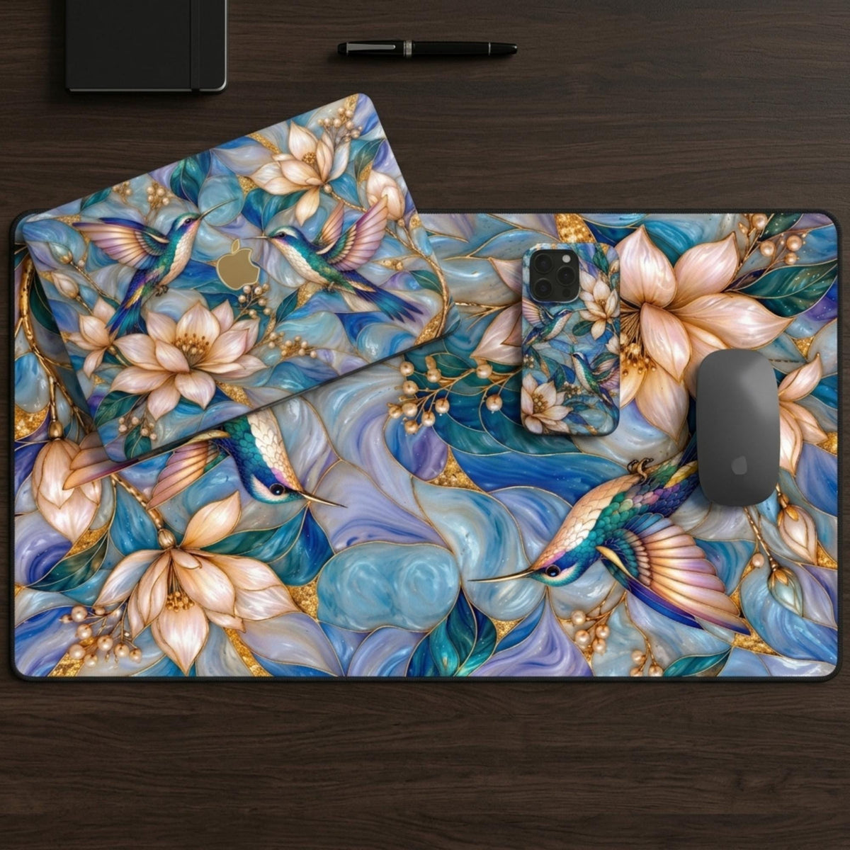 Matching set: hummingbird MacBook case, phone case and desk mat together on a desk.