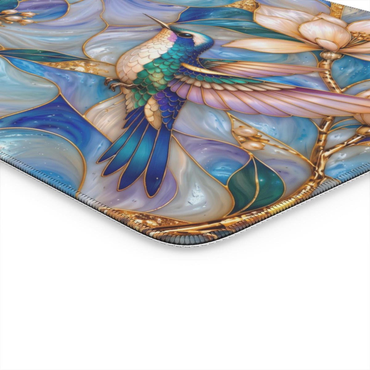 Close-up of the stitched edge and printed hummingbird detail on the desk mat.