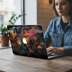 Woman working in cafe on MacBook with graffiti world map case, aesthetic travel laptop cover for her