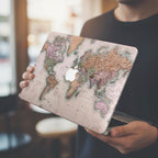 Person holding MacBook with vintage world map hard shell case, detailed cartographic print in rose and sage tones, personalized laptop cover