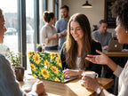 Woman smiling in coffee shop with sunflower MacBook case, personalized yellow floral hard shell laptop cover aesthetic lifestyle