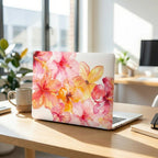Watercolor hibiscus MacBook case on clean office desk, pink coral floral laptop cover, bright modern workspace with natural light