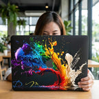 Woman holding up custom paint splash MacBook case, bold colorful rainbow abstract laptop cover with personalized initials, cafe with green plants