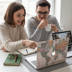 Personalized vintage world map MacBook case with Your Name placeholder in handwritten script, lifestyle photo with two people working together at desk