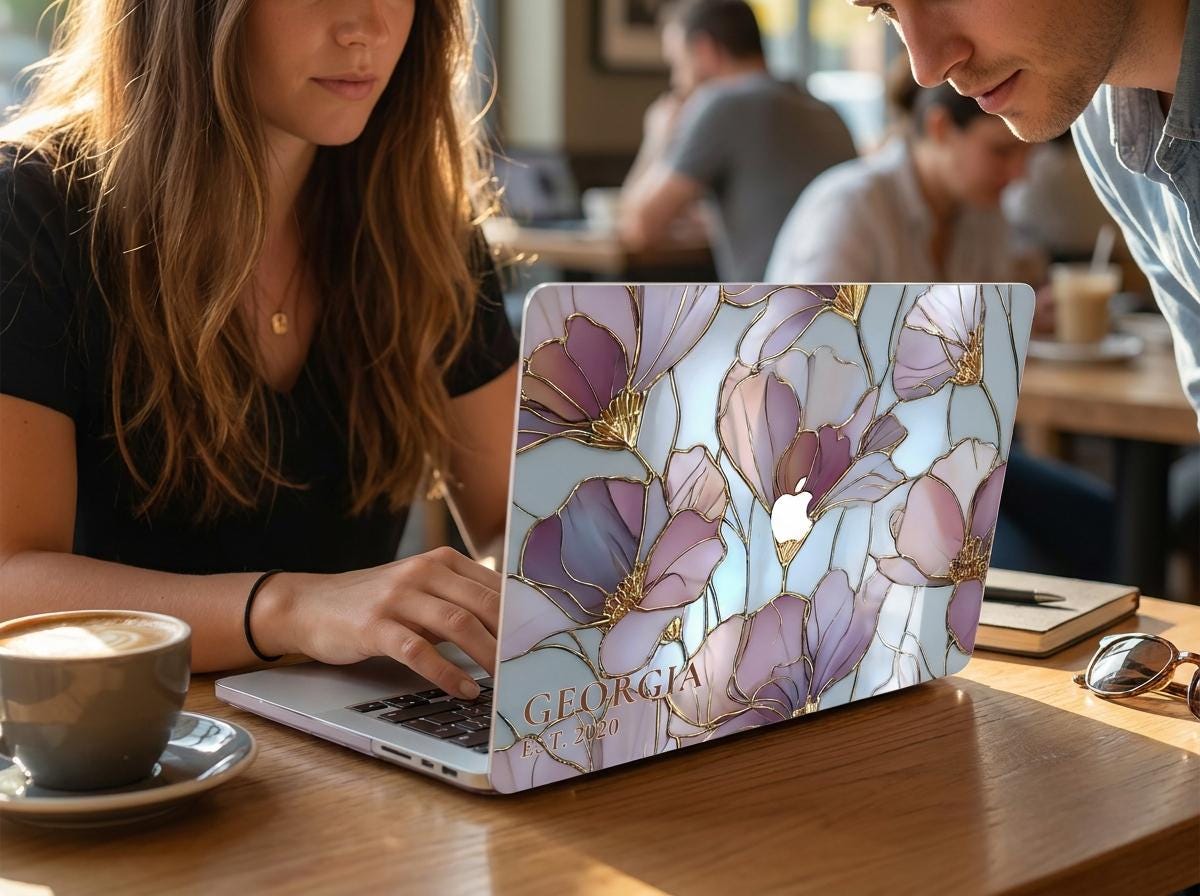 Two people working in cafe with custom name stained glass floral MacBook case, personalized purple gold magnolia hard shell laptop cover aesthetic workspace