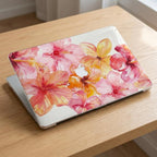 Watercolor hibiscus MacBook case flat lay on wooden surface, full cover pink coral floral print, closed laptop top view