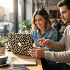 Smiling woman and man at sunny cafe table with leopard print MacBook case, cheetah pattern laptop cover, bright lifestyle moment