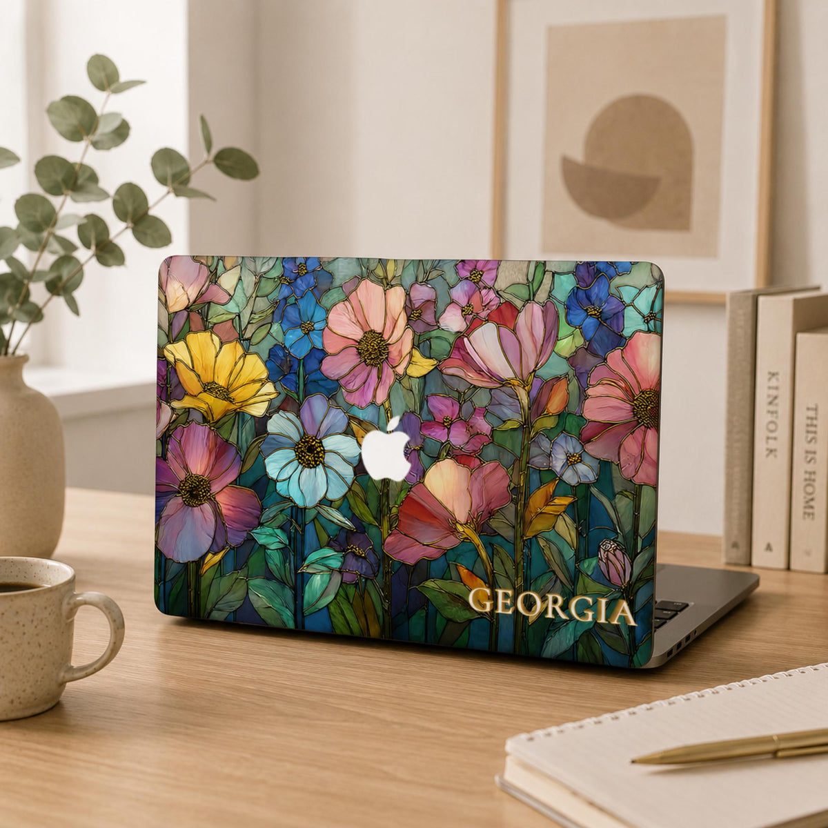 Colorful Garden floral MacBook case with the name Georgia on a wooden desk with eucalyptus, a mug and a notebook in warm natural light.