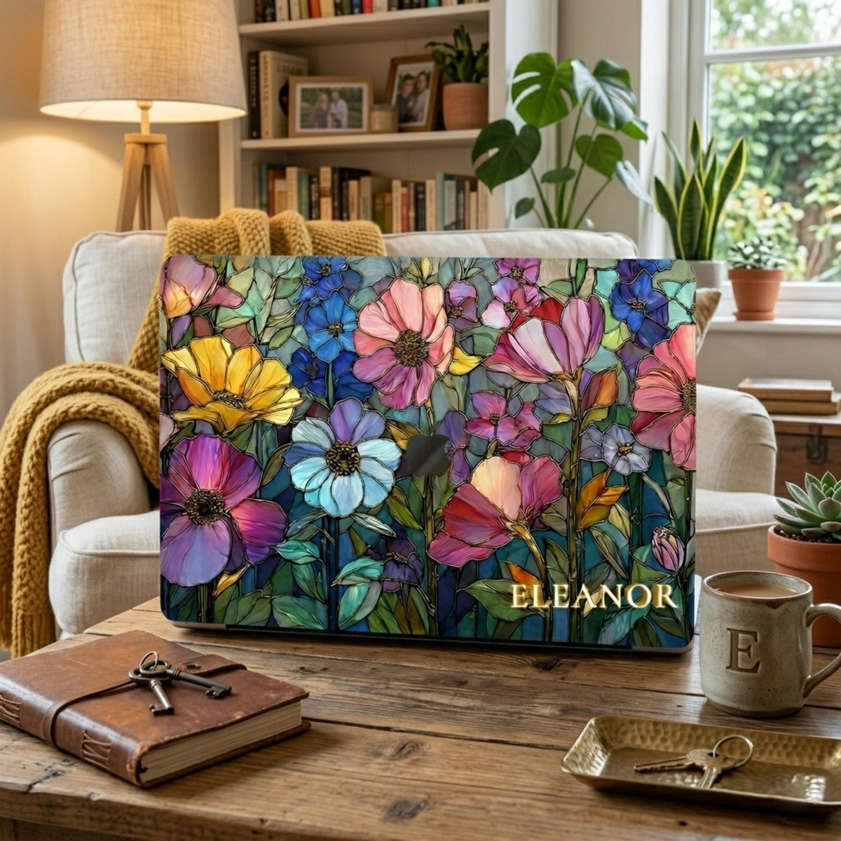 Colorful Garden MacBook case personalized with the name Eleanor on a rustic coffee table in a cozy living room.