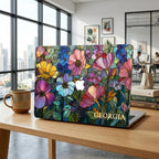 MacBook in the Colorful Garden stained glass effect case on a desk in a modern office with city-view windows and botany books.