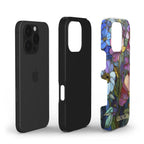Exploded product view of a personalized iPhone Tough Case showing its dual-layer construction with a black shock-absorbing inner liner and rigid printed outer shell. The outer layer features a colorful stained glass effect with pink, purple, blue and green botanical artwork, golden-looking printed outlines and the custom name Georgia. This view highlights the protective construction and full-wrap print. The stained glass appearance is a printed visual effect from TrioAuraDesign.