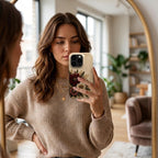 Personalized ivory embroidery effect floral iPhone case from TrioAuraDesign, shown in a mirror selfie. The smooth printed phone case features deep burgundy, ivory and dusty rose flowers with botanical greenery, berries and gold-toned details, with custom name personalization near the camera area. Elegant floral case with a realistic embroidered look and smooth finish, available in my shop for compatible iPhone models.