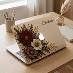 Personalized embroidery effect floral MacBook case from TrioAuraDesign, featuring deep burgundy, ivory and dusty rose flowers with green botanical leaves and gold-toned details on a warm ivory background. Custom name “Charlotte” appears at the upper right, with the Apple logo visible at center. Elegant hard shell laptop cover with a smooth printed finish, available in my shop for MacBook Air, Pro and Neo models.