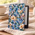 Hummingbird stained glass effect Kindle Paperwhite case on a cozy blanket with tea, Art Nouveau magnolia and hummingbird cover